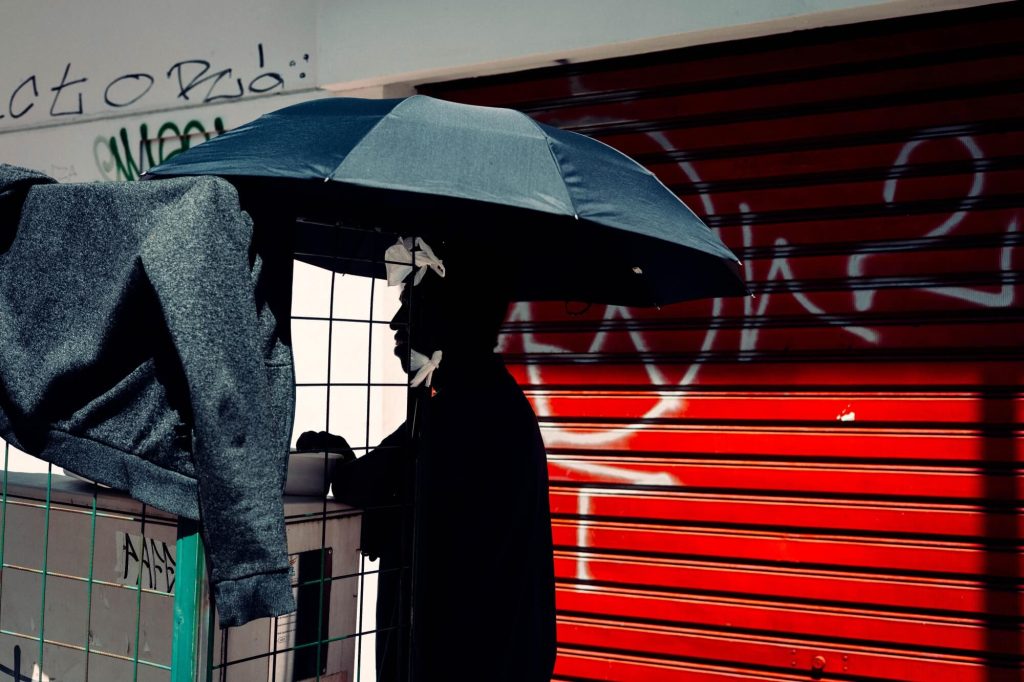Cena urbana com guarda-chuva e graffiti vermelho, fotografia de Alexandre de Olanda