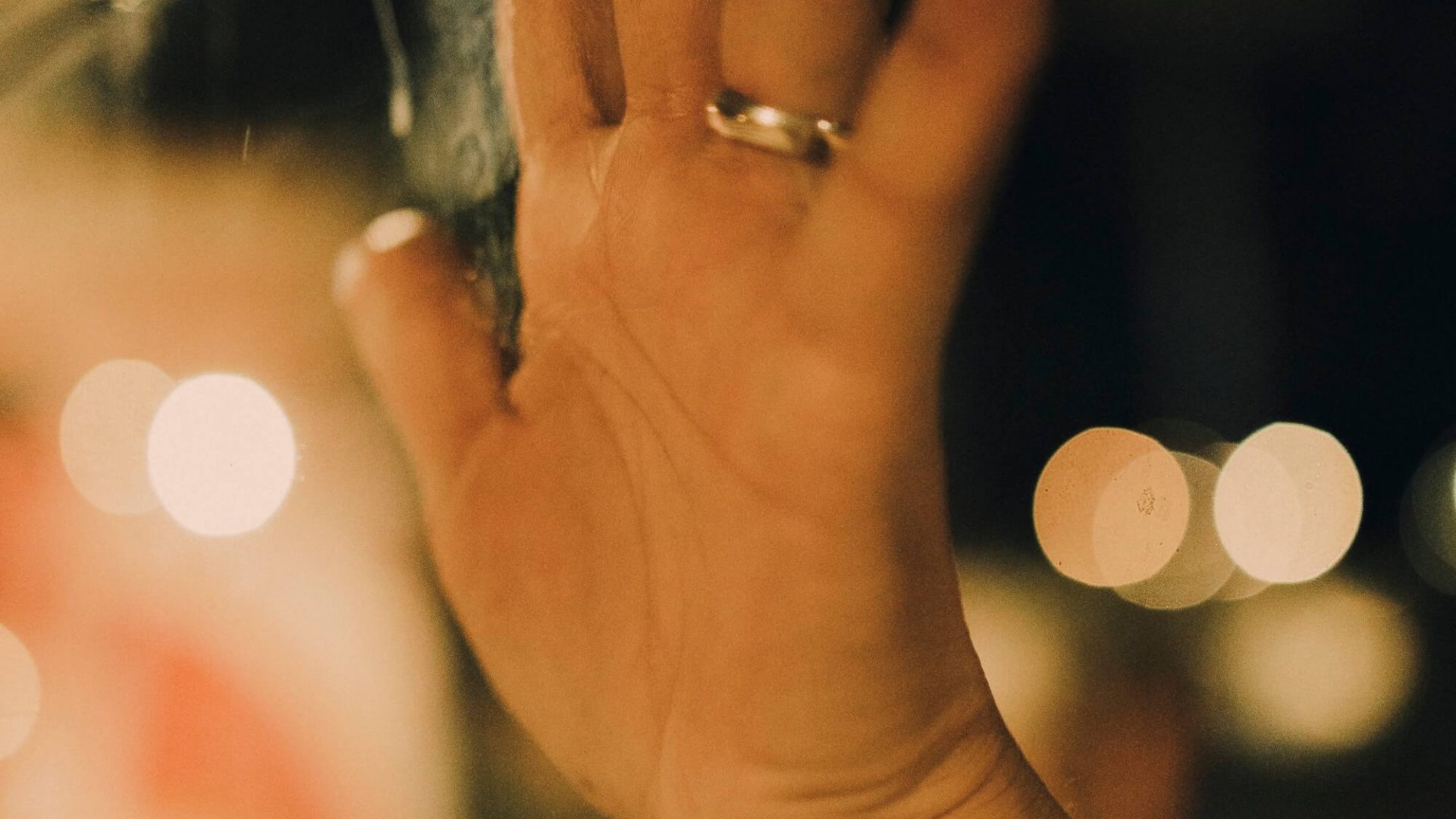Mão iluminada contra vidro com reflexos, fotografia de Alexandre de Olanda