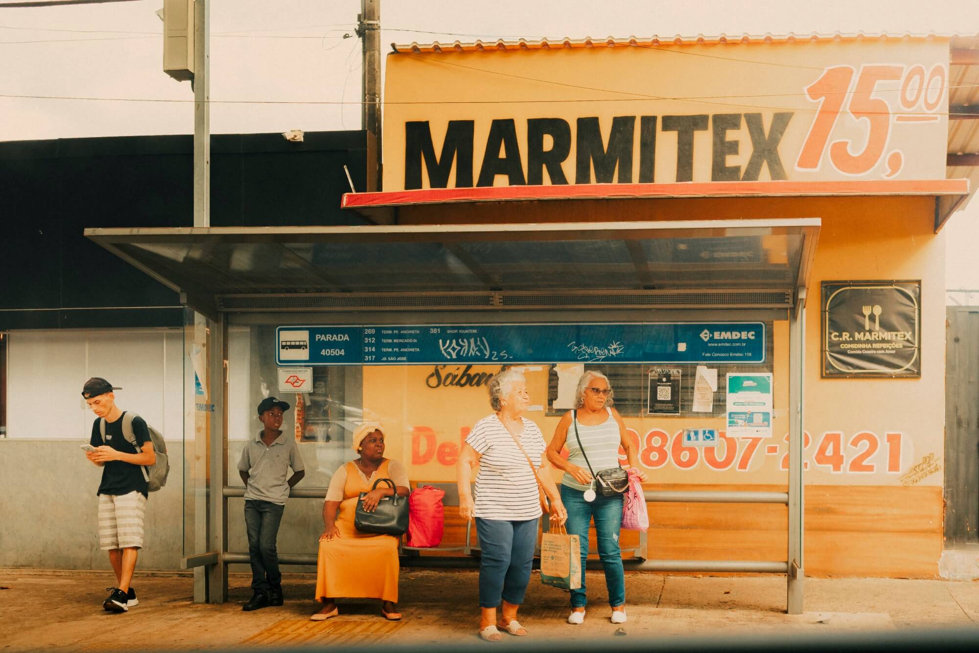 Ponto de ônibus com pessoas aguardando, fotografia de Alexandre de Olanda