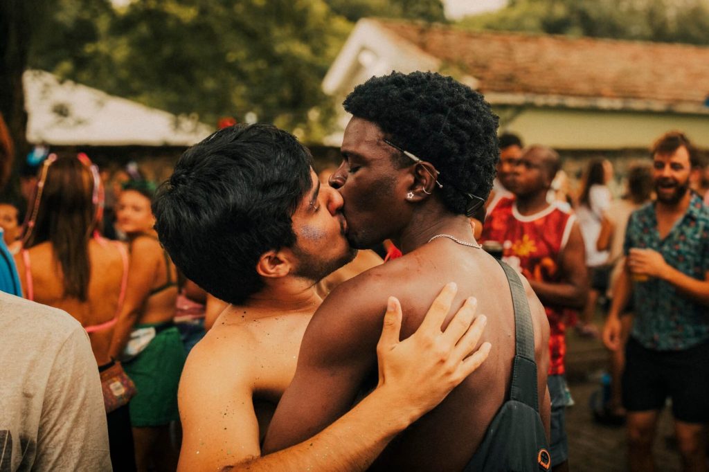 Casal se beijando em celebração coletiva, fotografia de Alexandre de Olanda