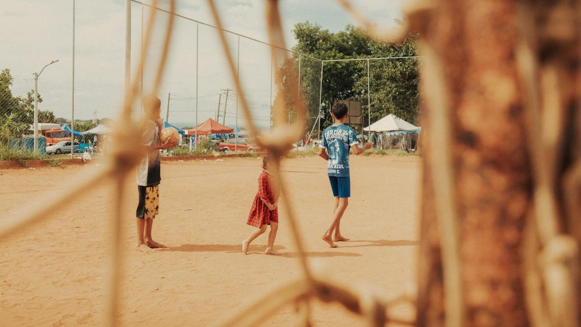 Crianças brincando em campo de areia, fotografia de Alexandre de Olanda